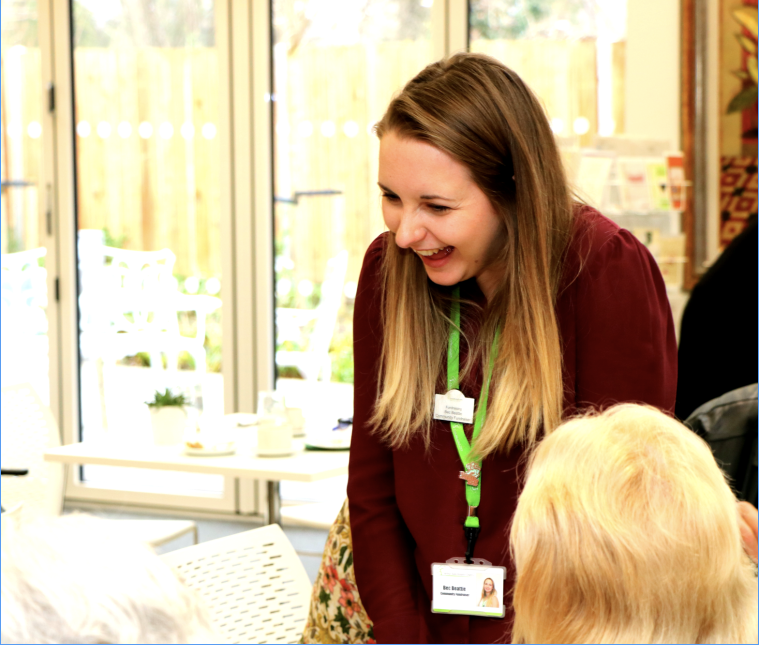 Colleagues laughing whilst speaking to Bistro visitors at Hospice