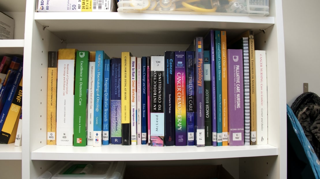 Colourful books stacked on a shelf in the Hospice's Library