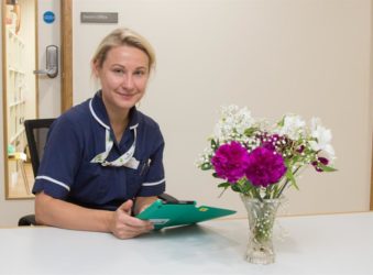 Inpatient Unit nurse in blue uniform holding iPad