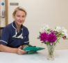 Inpatient Unit nurse in blue uniform holding iPad