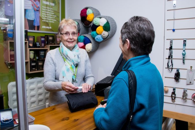 Lady standing at till paying
