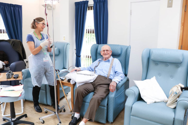 Man smiles whilst receiving treatment from nurse