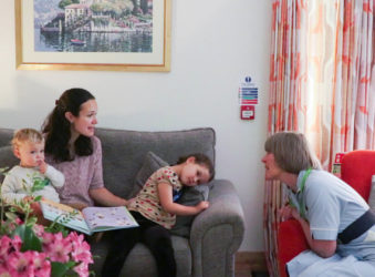 Woman with two young children talks to a Nurse