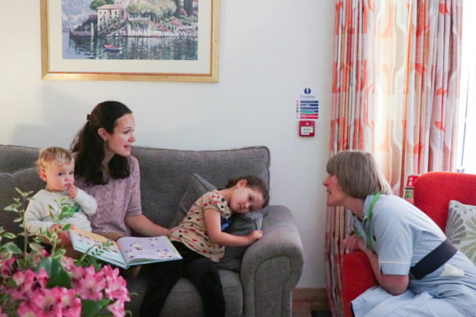Woman with two young children talks to a Nurse