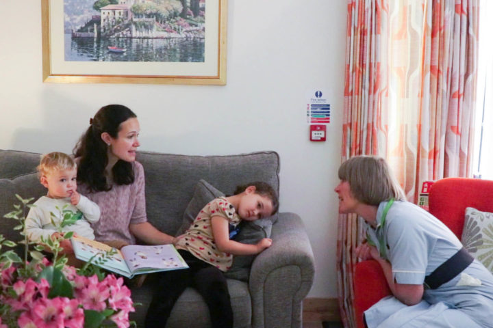 Woman with two young children talks to a Nurse