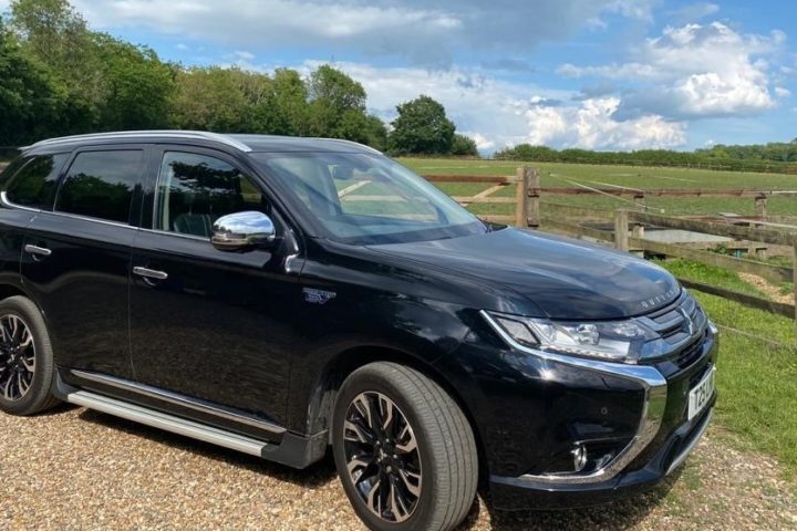 Car in front of field on sunny day