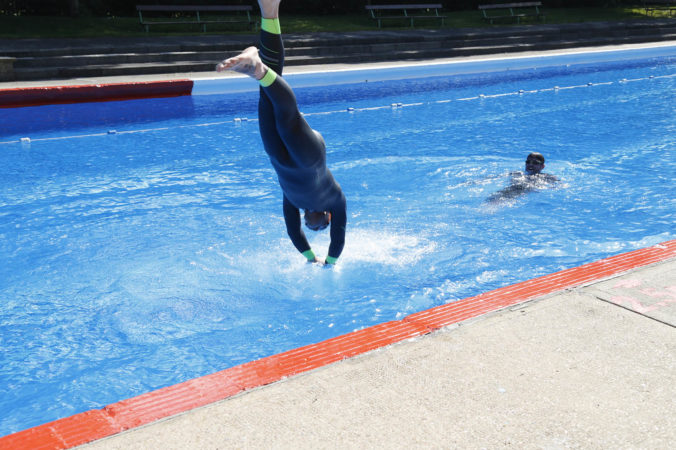 A diver landing in a swimming pool