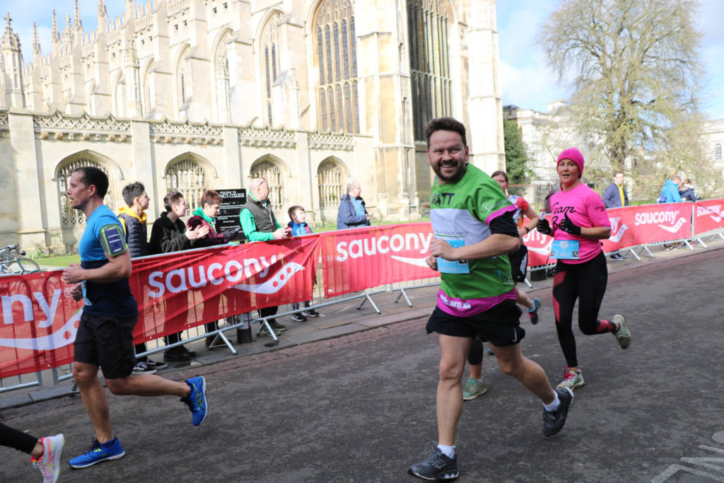 Male running in front of Kings College Cambridge