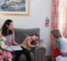 Woman with two young children talks to Nurse