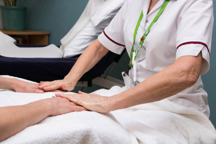 Patient's hands on towel as Therapist delivering hand massage