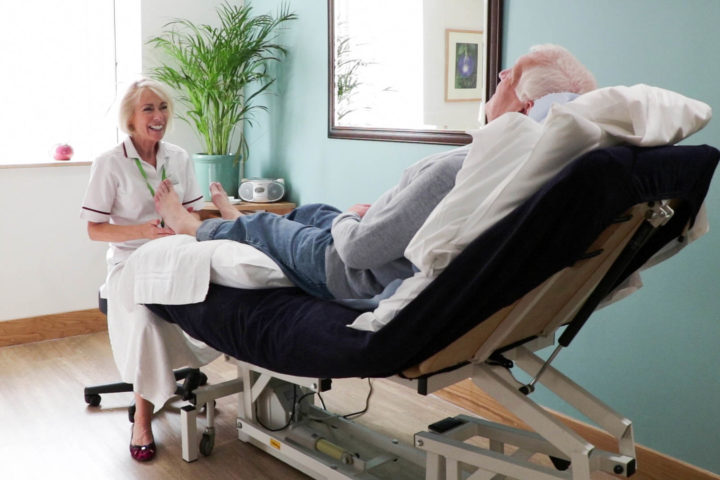 Therapist delivering reflexology to a patient, in on of the Hospice's therapy rooms