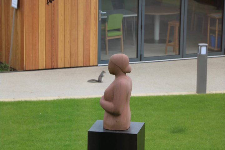 Statue of a Woman in foreground with squirrel behind as if having a chat