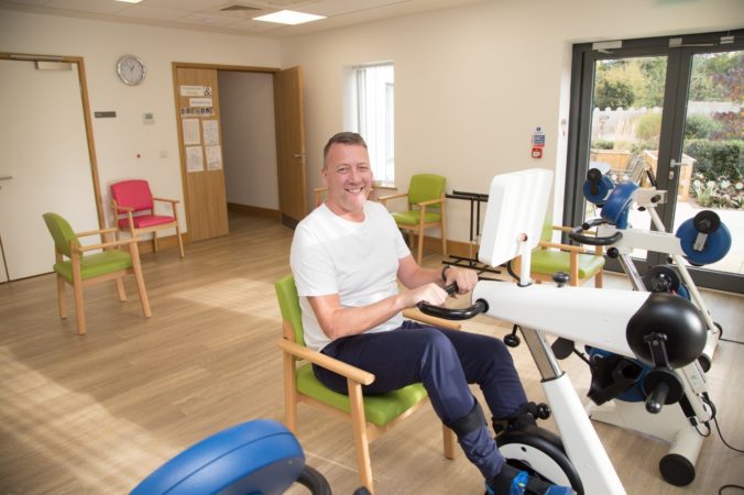 Male patient using the bike in the gym