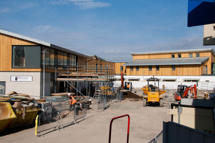 Yellow machines and building with scaffolding