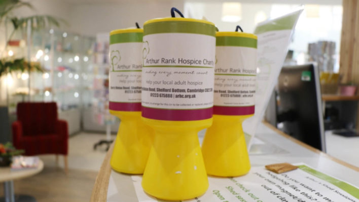 Three bright yellow collection tins with Arthur Rank Hospice Charity labels