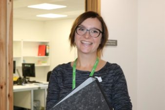 Female holding a folder smiling
