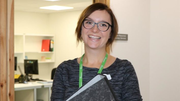 Female holding a folder smiling