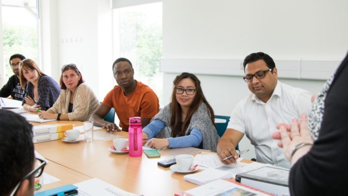 Diverse group of students at a table, being taught in the Hospice's Education & Conference Centre