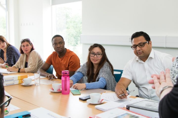 Diverse group of students at a table, being taught in the Hospice's Education & Conference Centre