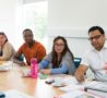 Diverse group of students at a table, being taught in the Hospice's Education & Conference Centre
