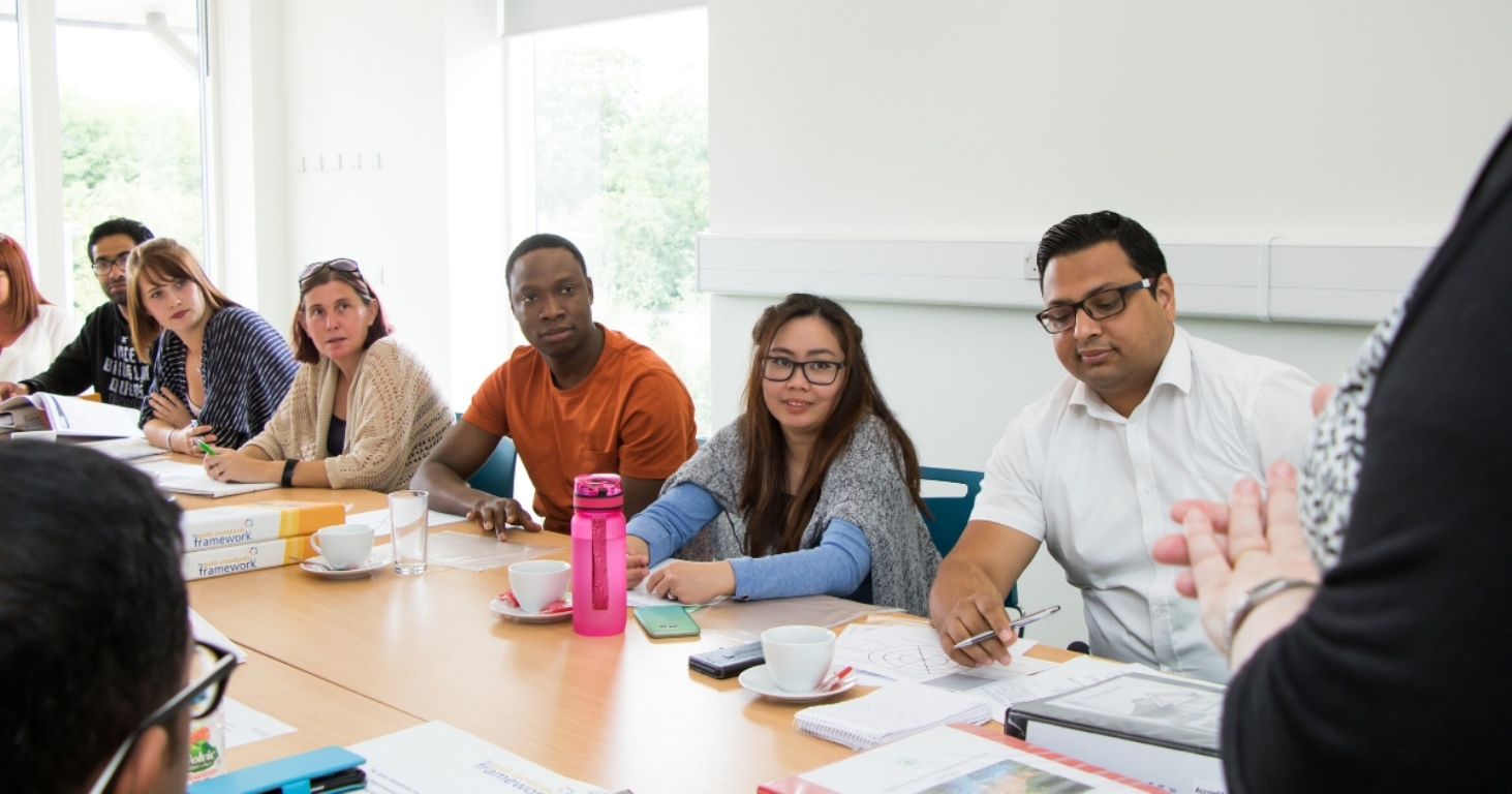 Diverse group of students at a table, being taught in the Hospice's Education & Conference Centre