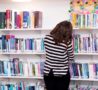 A woman looks through books in a library