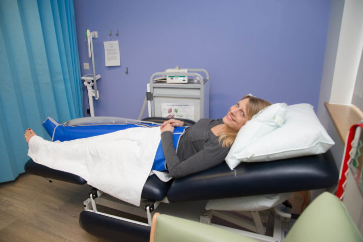 Patient on bed with bandaged leg, in clinic room