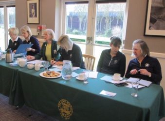 Females wearing dark green sitting at a table