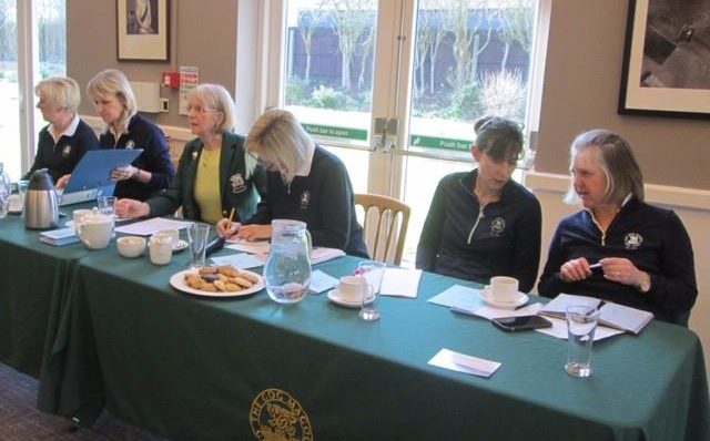 Females wearing dark green sitting at a table