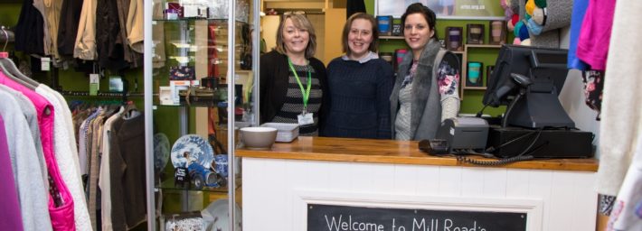 Shops team behind the counter at our Mill Road charity shop