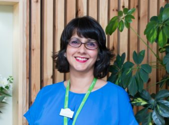 Female wearing blue smiling at the camera