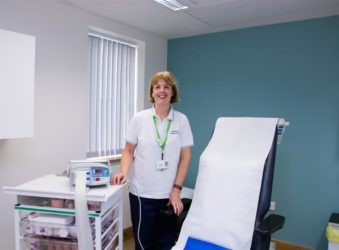 Female wearing white tshirt next to clinic bed