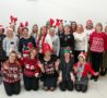 Group of colleagues wearing Christmas jumpers and hats