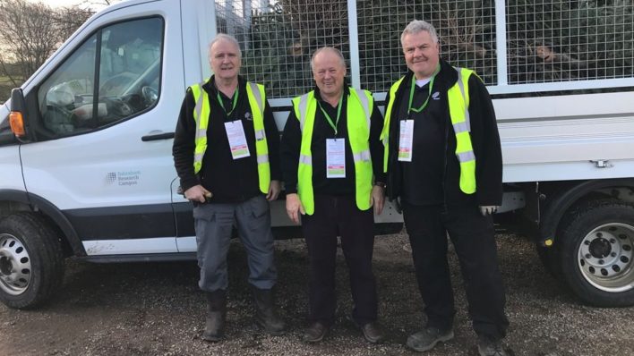 3 males near a van with high vis