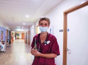 Doctor Jenny wearing burgundy scrubs and a facemask on the Inpatient Unit