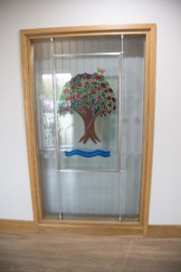 Arthur Rank Hospice Charity proudly displays the Royal stained glass window, previously housed at the Mill Road site, in the Evelyn Day Therapy Window at Shelford Bottom, Cambridge