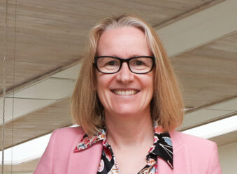 Female smiling at the camera wearing pink