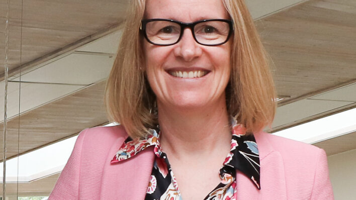 Female smiling at the camera wearing pink