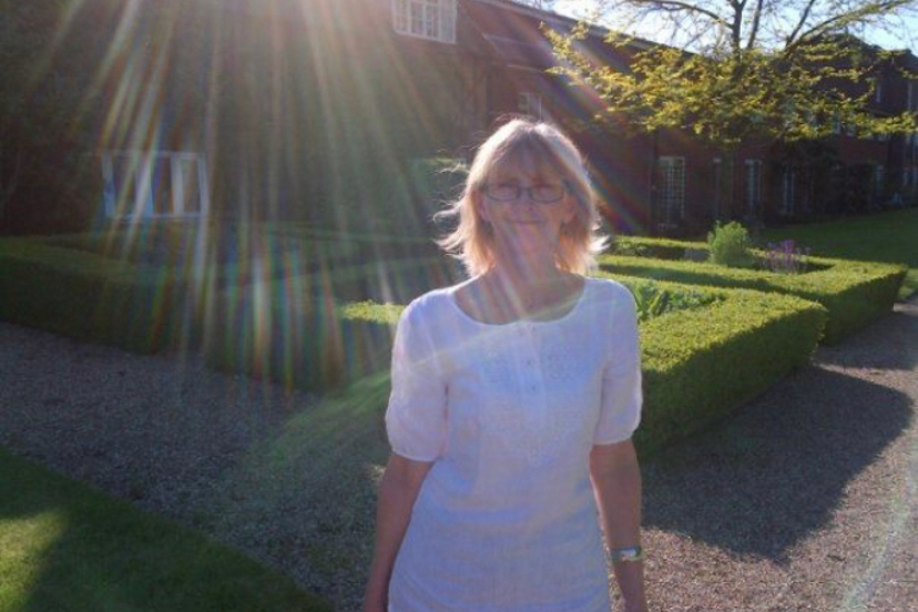 Linda with rays of sun behind her head, in a white dress enjoying a day at Champneys with Natalie in 2016