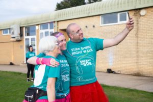 3 Star Shine Night Walkers dressed in green t-shirts smiling as they take a selfie