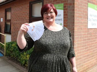 Female outside Alan Hudson Day Treatment Centre with raffle rickets