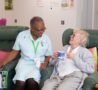 Female patient with a cup of tea, chats to healthcare assistant in the Evelyn Living Well Centre at Arthur Rank Hospice Charity