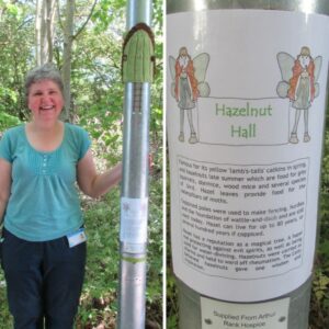 Lady smiling wearing a green top next to a green and brown knitted door on the lamp post leading to Arthur Rank Hospice