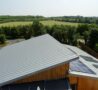 Roof and solar panels at Arthur Rank Hospice with green trees and fields in the background