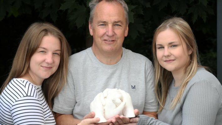 Dad with daughters either side, all holding hand-cast together