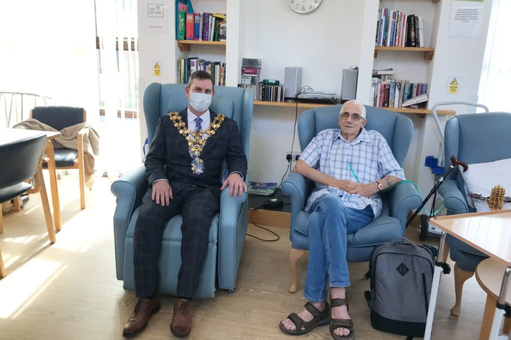 The Mayor of Wisbech sittingon a chair with a male patient sitting on a chair next to him 