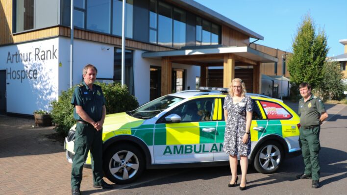 Director of Clinical Services, Sara Robins with members two members of EAAST and an ambulance car outside Arthur Rank Hospice Charity's Shelford based home