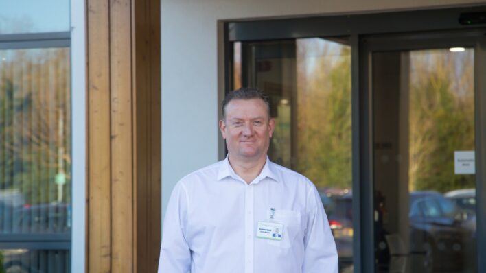 Male wearing a white shirt standing outside Arthur Rank Hospice Charity