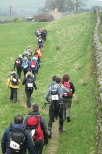 Walkers walking next to Hadrians Wall