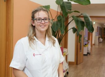 Female wearing a white OT uniform standing in the corridor at Arthur Rank Hospice